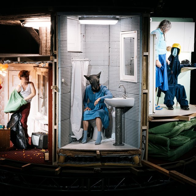 Person med dyremaske siddende på et toilet. 