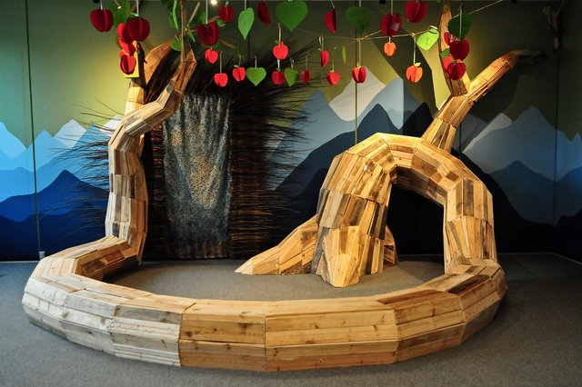 Kunstværk der forestiller en stor gren, der ligger på gulvet. Over grenen er der et æbletræ.