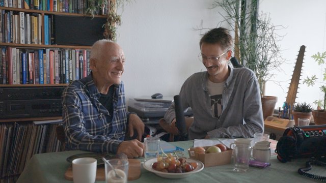 To mænd, siddende ved et bord. 