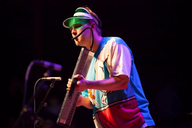 Musiker på scenen med instrument.