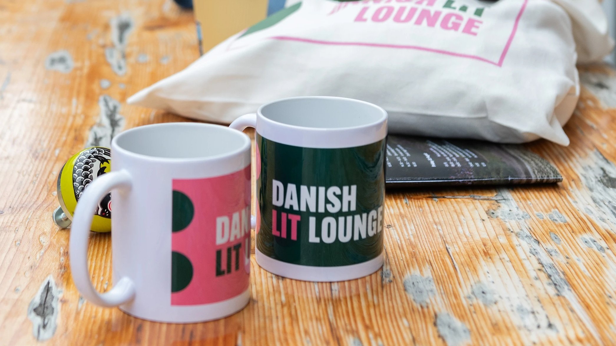 Two coffee mugs with Danish Lit Lounge logo