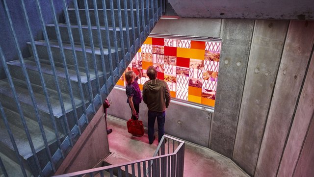 To mennesker kigger på farvet kunst i en trappeopgang