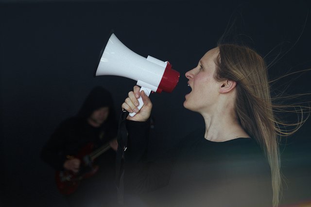 Kvinde råber i megafon